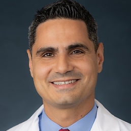 Dr. Nestoras Mathioudakis smiles for a photo wearing his white coat.