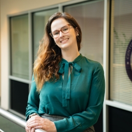 Amelia Wallace smiles for a professional photo at the 2024 E. Monument Street building.