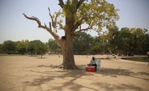 A man takes rest from selling water bottles on a hot afternoon near India Gate in Delhi.