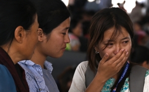 A woman cries as she waits at the Imphal airport to flee ethnic violence in the northeastern Indian state of Manipur on May 7, 2023.