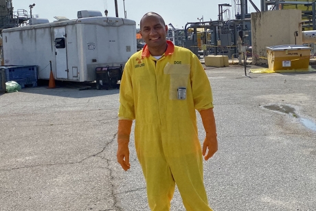 Young male on paved worksite in yellow safety suit