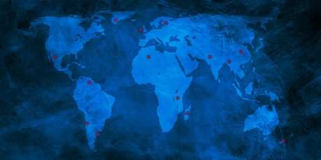 Blue map of the world with red spots indicating countries covered in GHN&#039;s Covid country series so far