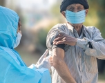 A health care provider gives man a COVID vaccine