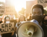 Black man holding megaphone protesting to end racism