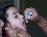 Young girl receiving liquid polio vaccine