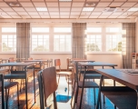 Photograph of an empty school classroom with bright light shinning through the windows.