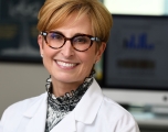 Photo of Sabra Klein in a white lab coat