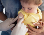 nurse placing bandaid on a child after vaccine