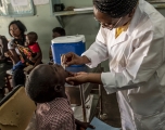 A health worker administers oral cholera vaccine to a child in Zambia.  