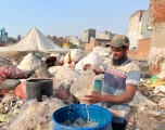 Mohammad Hanif washes recyclable materials pulled from the Bhalswa landfill in Delhi, on October 5, 2022. Image by Cheena Kapoor