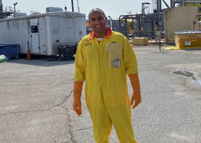 Young male on paved worksite in yellow safety suit