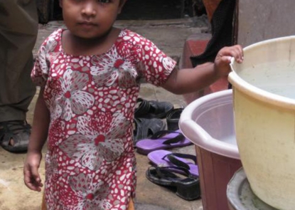A young girl in Kolkata, India, stands by her family's cholera-contaminated water supply.